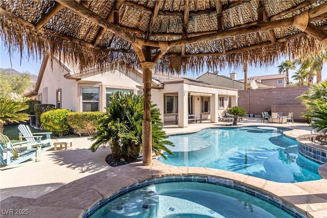 view of swimming pool featuring a patio area, an in ground hot tub, a gazebo, and fence