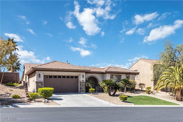 view of front of home with stucco siding, concrete driveway, a garage, stone siding, and a tile roof