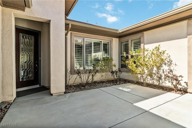 doorway to property with a patio and stucco siding