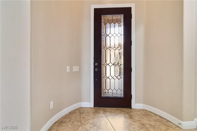 foyer with light tile patterned flooring and baseboards