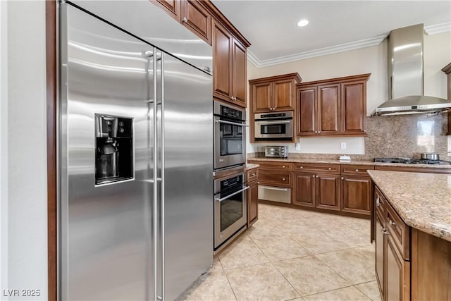 kitchen with built in refrigerator, ornamental molding, backsplash, light tile patterned flooring, and wall chimney range hood