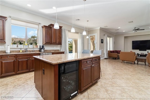 kitchen featuring a sink, plenty of natural light, beverage cooler, and ornamental molding