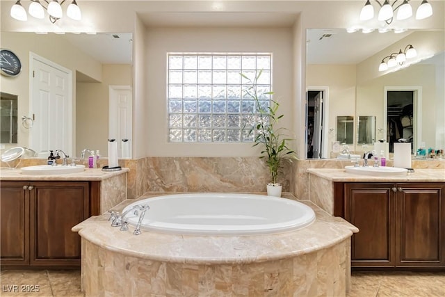 full bath with a sink, two vanities, and tile patterned floors