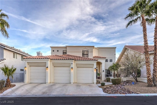 mediterranean / spanish-style home with stucco siding, fence, concrete driveway, an attached garage, and a tiled roof