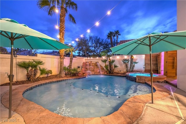 view of swimming pool with a pool with connected hot tub and a fenced backyard