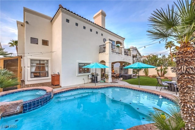 view of pool with a patio area and a pool with connected hot tub