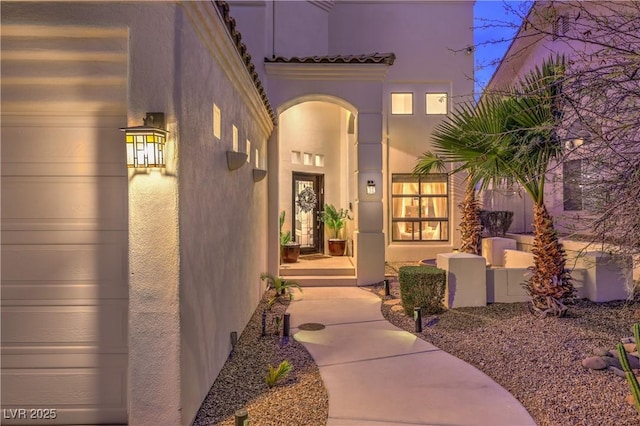 doorway to property with stucco siding and a tile roof