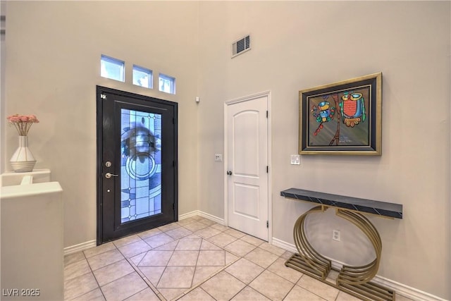 foyer with light tile patterned floors, visible vents, and baseboards