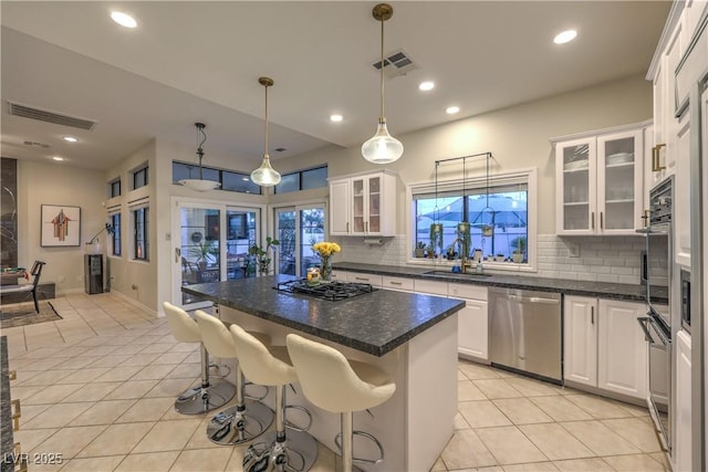 kitchen featuring visible vents, light tile patterned floors, stainless steel dishwasher, gas stovetop, and a sink