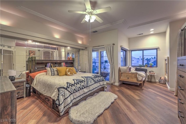 bedroom with visible vents, wood finished floors, crown molding, baseboards, and access to exterior