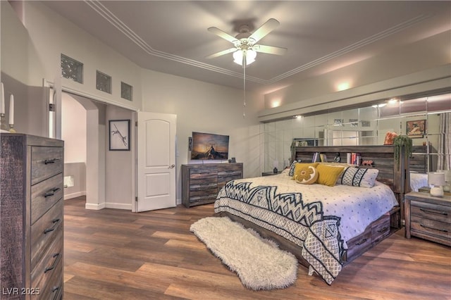 bedroom featuring visible vents, wood finished floors, arched walkways, crown molding, and baseboards