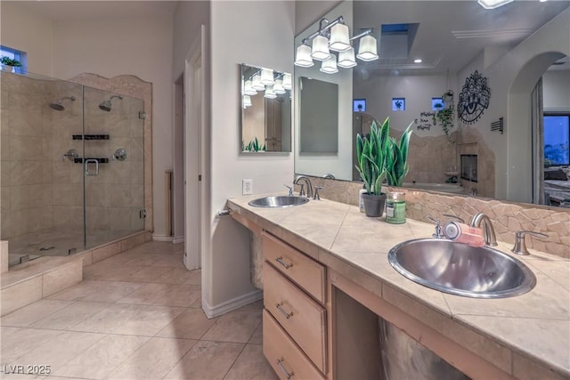 full bathroom with tile patterned flooring, a shower stall, double vanity, and a sink