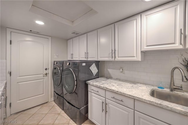 laundry area with washing machine and dryer, recessed lighting, light tile patterned flooring, cabinet space, and a sink