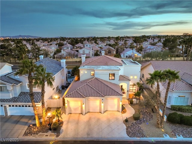 view of front of house featuring stucco siding, a residential view, concrete driveway, and a tile roof