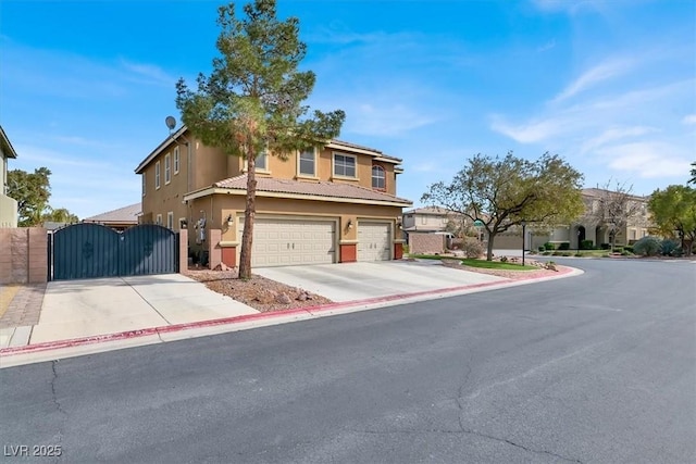 view of front facade featuring concrete driveway, a gate, an attached garage, and stucco siding