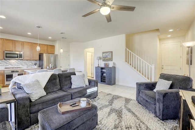 living room with light tile patterned floors, recessed lighting, stairs, and ceiling fan