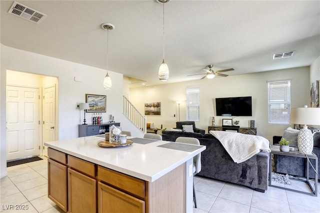 kitchen featuring light countertops, open floor plan, visible vents, and a center island