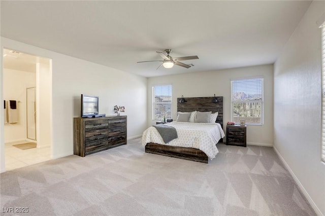 carpeted bedroom featuring baseboards, ensuite bathroom, and a ceiling fan