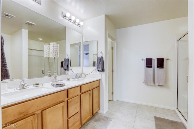 bathroom with tile patterned floors, visible vents, a sink, a shower stall, and double vanity