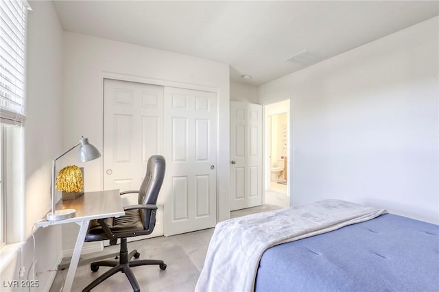 bedroom featuring light colored carpet, visible vents, and a closet