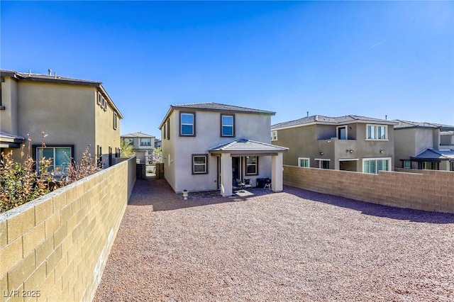 back of house featuring stucco siding, a residential view, and a fenced backyard