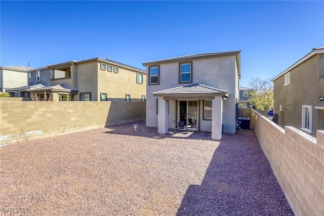 rear view of property featuring central air condition unit, a patio area, a fenced backyard, and stucco siding