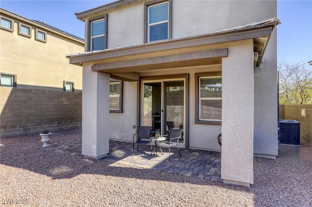 rear view of house with stucco siding, fence private yard, and a patio