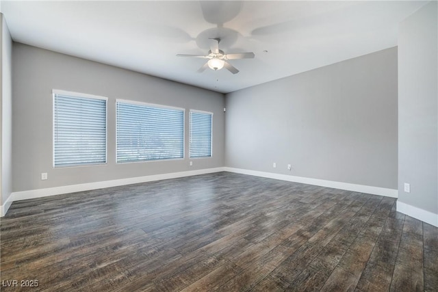 empty room featuring baseboards, ceiling fan, and dark wood-style flooring