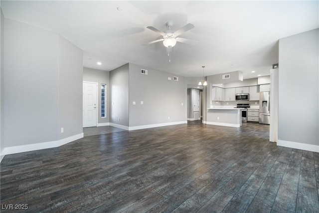 unfurnished living room featuring visible vents, dark wood-type flooring, baseboards, recessed lighting, and ceiling fan with notable chandelier