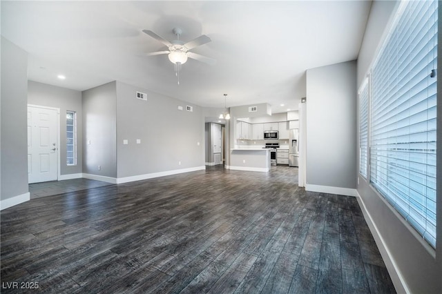 unfurnished living room featuring a ceiling fan, visible vents, dark wood-style flooring, and baseboards