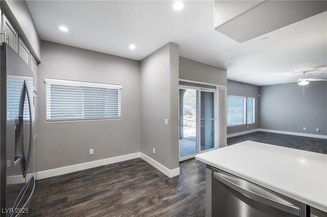 kitchen with baseboards, dark wood finished floors, light countertops, recessed lighting, and stainless steel appliances