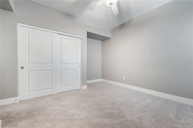 unfurnished bedroom featuring a closet, baseboards, carpet, and a ceiling fan