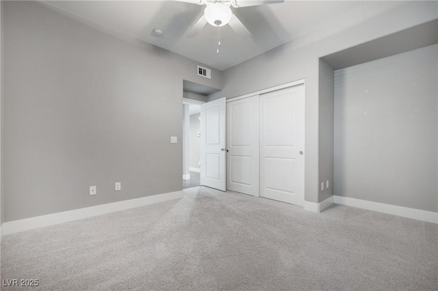 unfurnished bedroom featuring carpet, baseboards, visible vents, and a closet