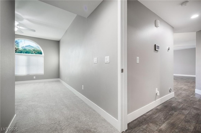 hall featuring baseboards, carpet floors, and wood finished floors