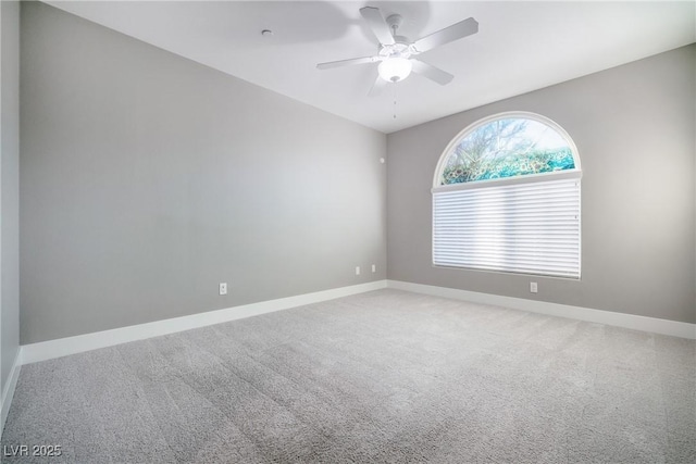 empty room featuring light colored carpet, baseboards, and ceiling fan