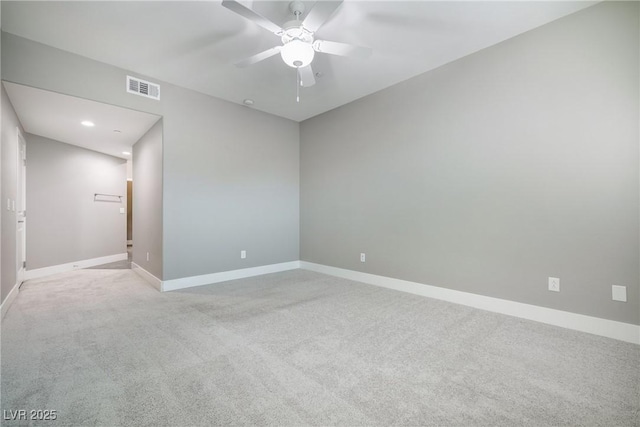 carpeted spare room featuring visible vents, ceiling fan, and baseboards