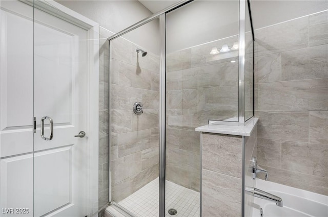 bathroom with a shower stall and a bathtub