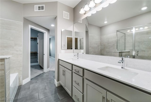 bathroom with visible vents, a shower stall, and a sink