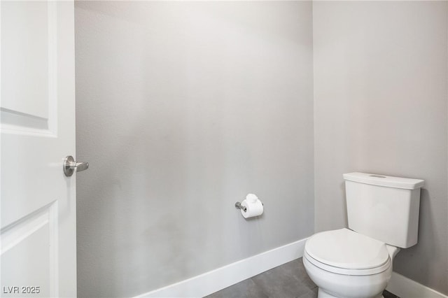 bathroom featuring toilet and baseboards