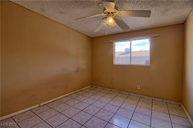 spare room featuring light tile patterned floors, baseboards, a textured ceiling, and a ceiling fan