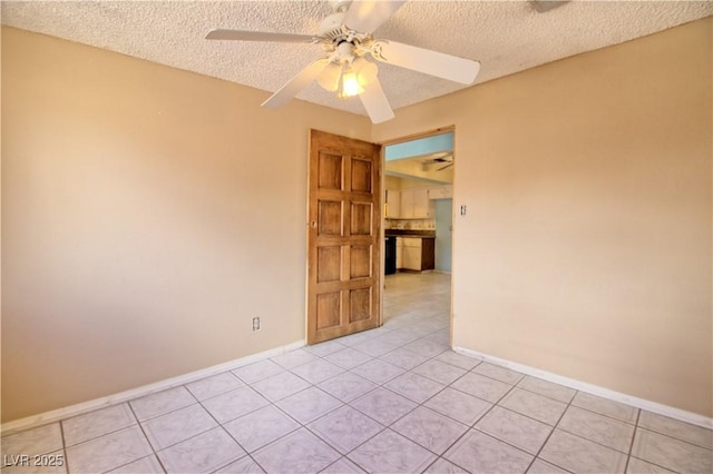 spare room with light tile patterned floors, baseboards, a textured ceiling, and a ceiling fan