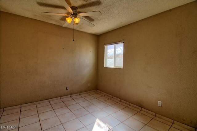 spare room featuring light tile patterned floors, a textured ceiling, and ceiling fan