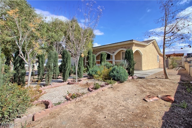 exterior space featuring stucco siding and fence