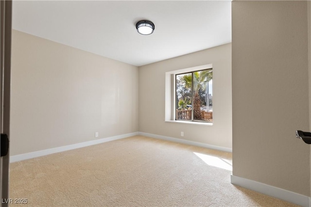 unfurnished room featuring baseboards and light colored carpet