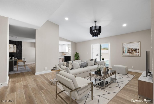 living room with recessed lighting, baseboards, and light wood finished floors