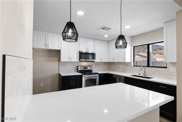 kitchen with stainless steel appliances, light countertops, and a sink