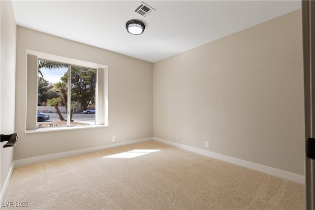 carpeted empty room featuring visible vents and baseboards