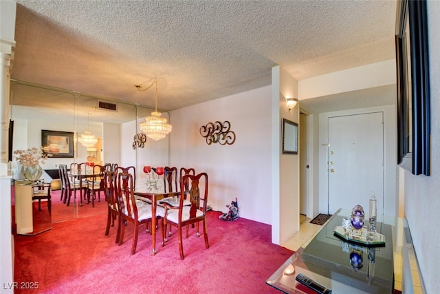 dining area featuring visible vents, a textured ceiling, and carpet floors