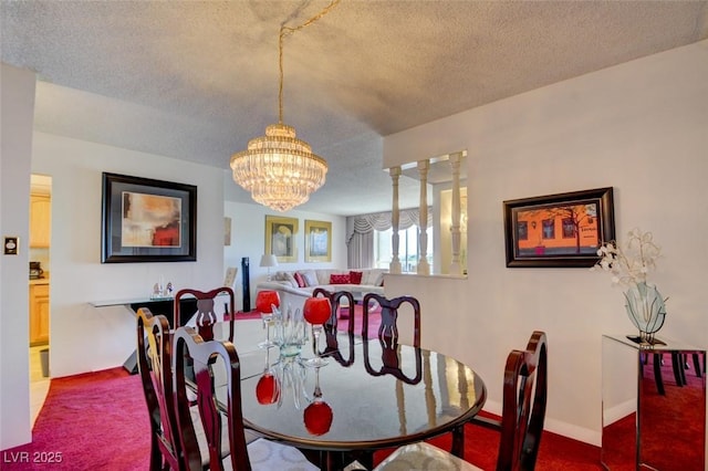 dining space featuring a notable chandelier, baseboards, and a textured ceiling