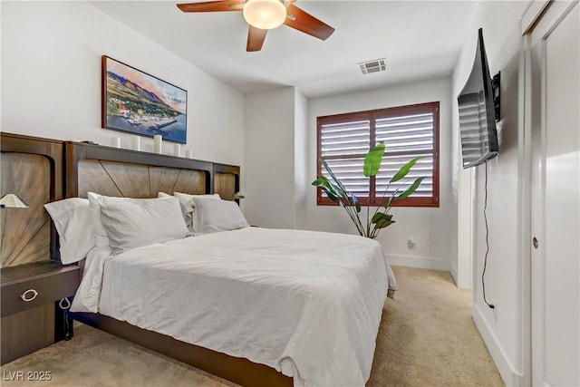 bedroom with visible vents, baseboards, light colored carpet, and ceiling fan